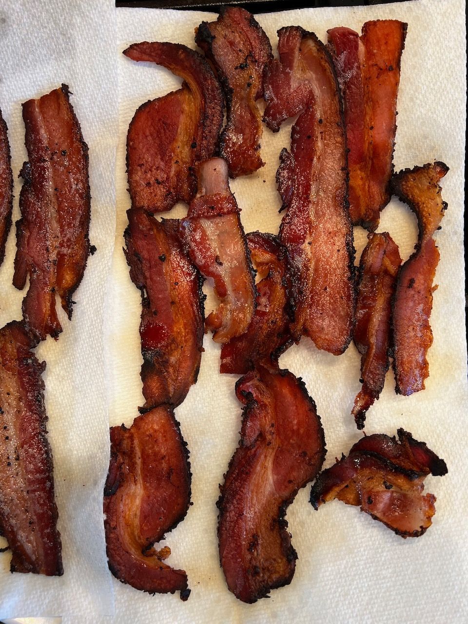 Pan-fried bacon de-greasing on a paper towel.