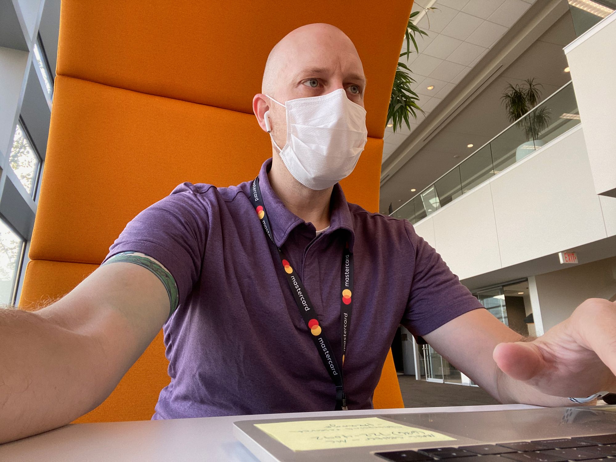 Stephen Bolen, masked, sitting at a table at work.