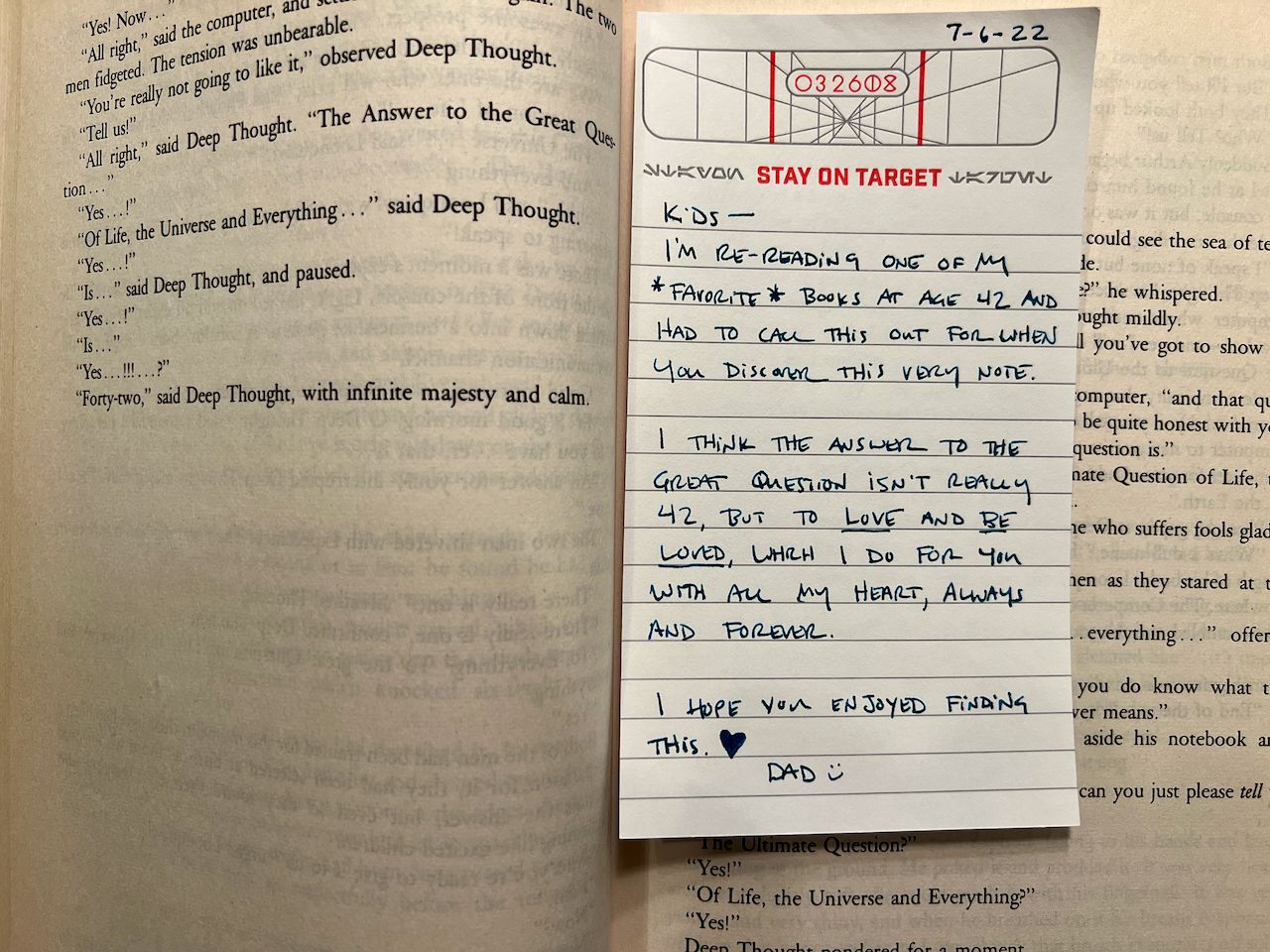 A note placed in a copy of a book that reads "Kids - I'm re-reading one of my favorite books at age 42 and had to call this out for when you discover this very note. I think the answer to the great question isn't really 42, but to Love and Be Loved, which I don you with all my heart, always and forever. I hope you enjoyed finding this. <3 Dad :)